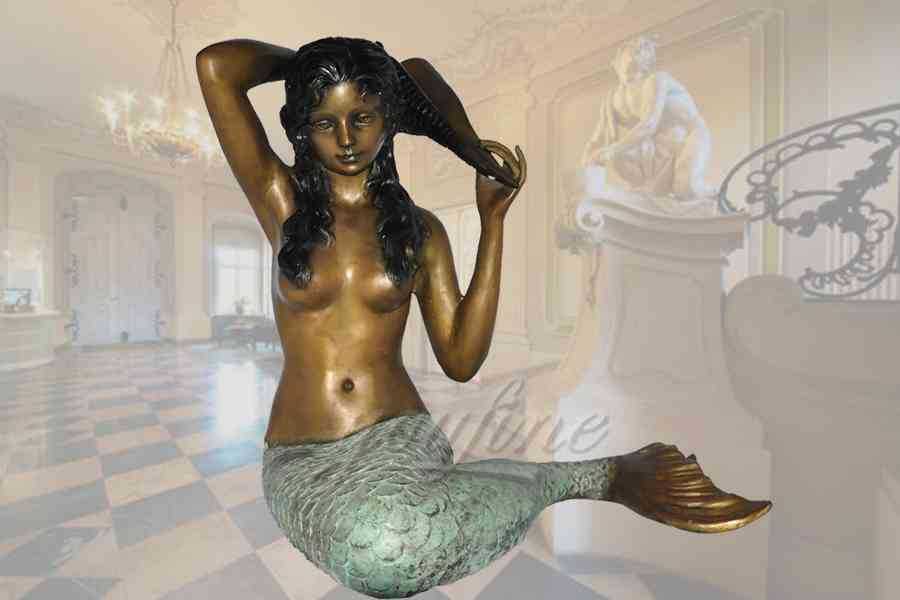 Elegant young sitting bronze mermaid statue with seashell