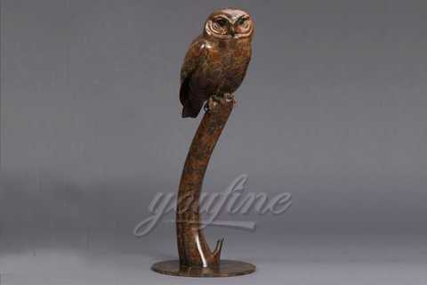 bronze owl statue on tree