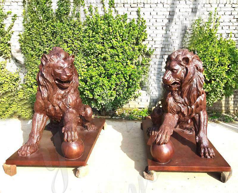 bronze lion statues with paw on ball