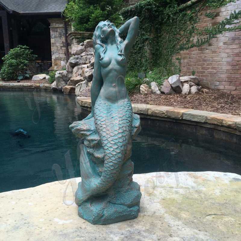 Life Size Bronze Patina Mermaid Statue Sitting on Coastal Rock Beach