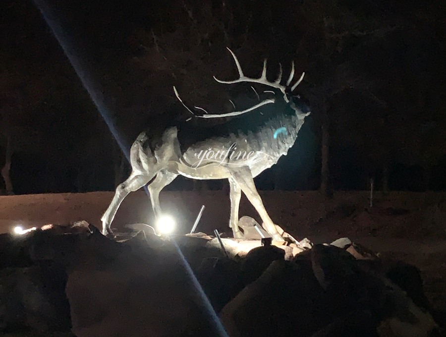 large elk statue with light installation