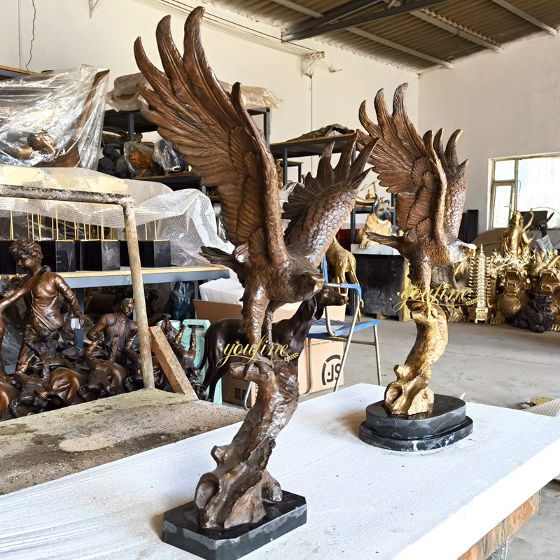 two Eagle sculptures standing on a tree stump