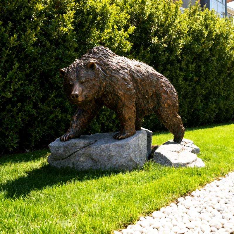 walking brown bear statue on rock