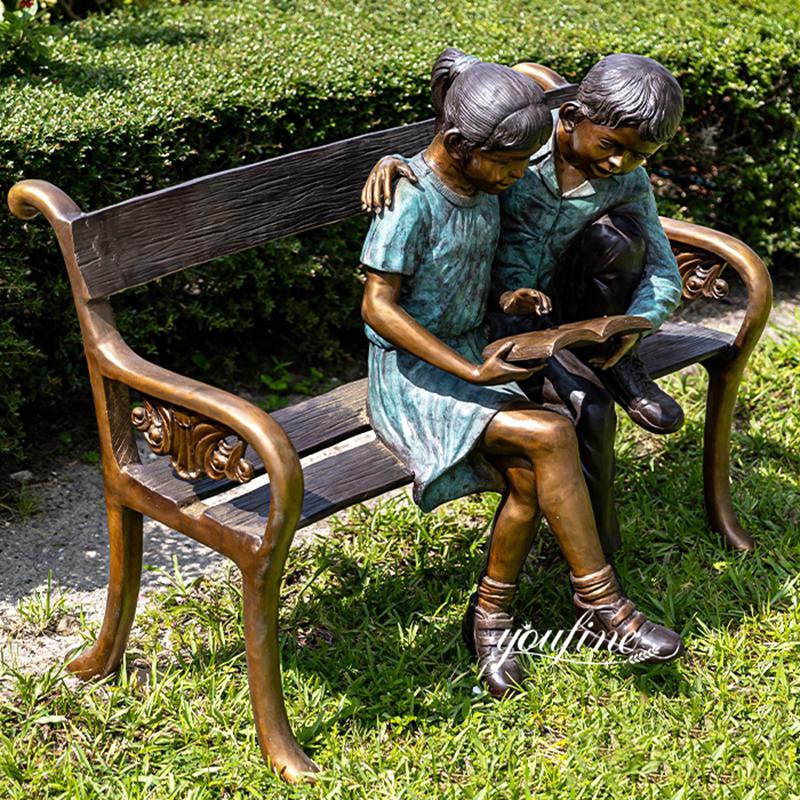 boy and girl sitting on a bench garden statue