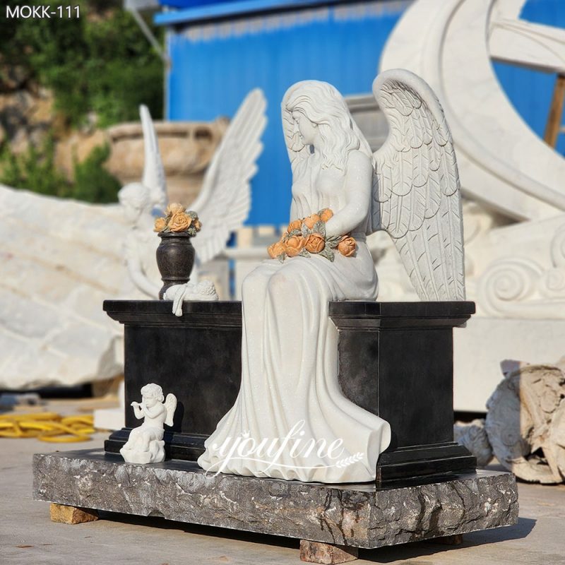 Lápida con forma de ángel sentado, hecha de granito negro y mármol.