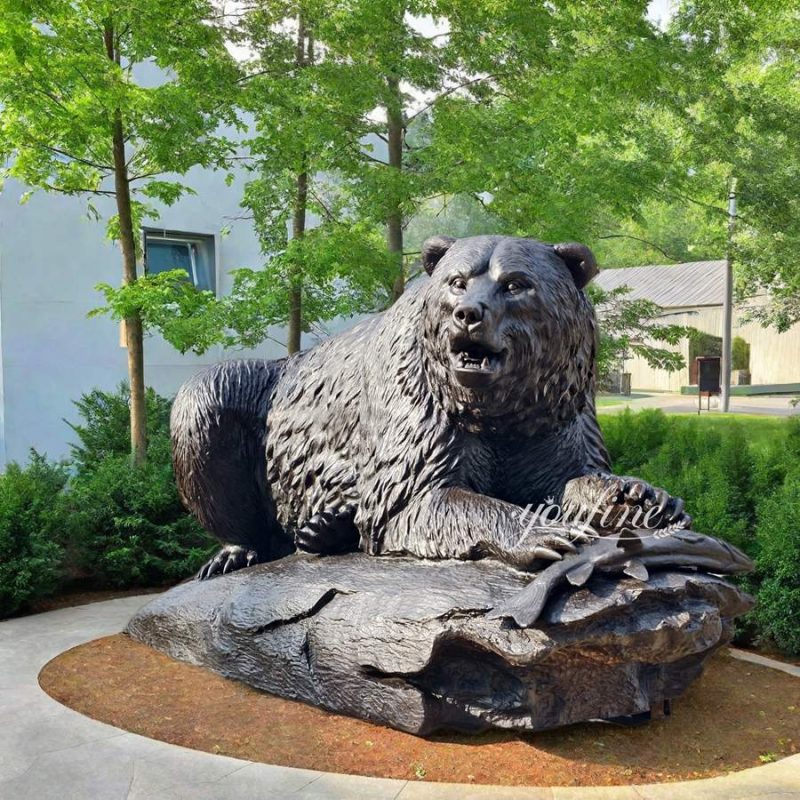 lying bear with fish statue