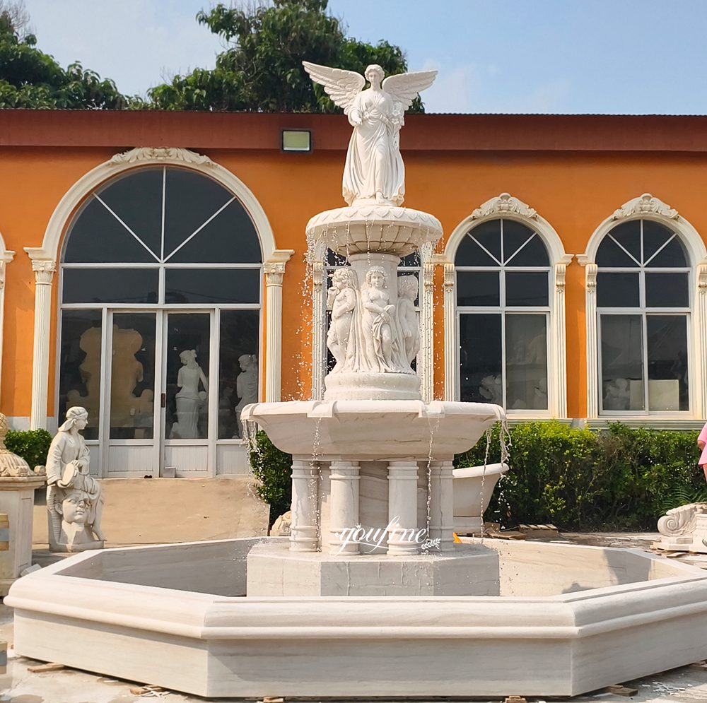 A standing angel sculpture marble fountain