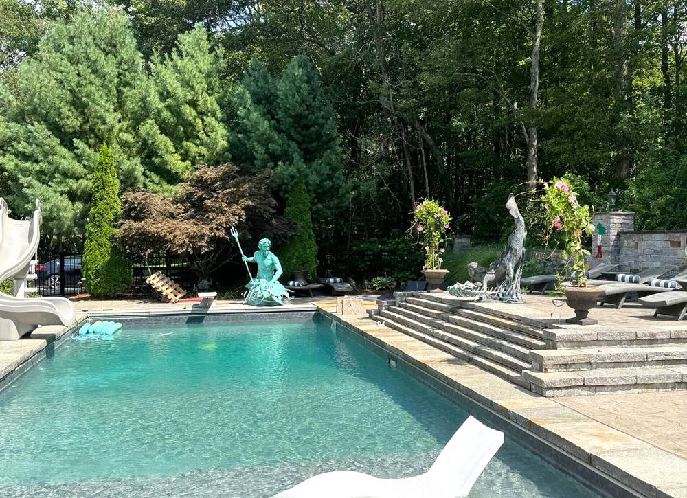 Sculptures of the Sea God and a Mermaid, placed beside a swimming pool