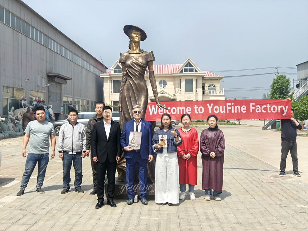 Ein Gruppenfoto der YouFine Fabrikhandwerker, Herr Berlin Irishev und die Skulptur