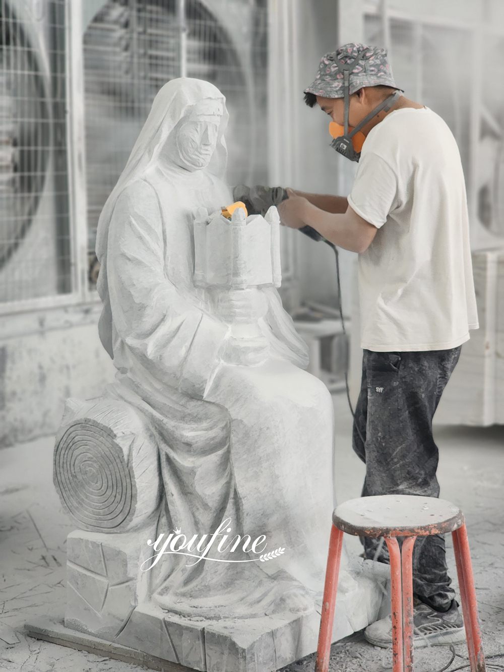 Un maître sculpteur façonne à la main une statue personnalisée de la Vierge Marie en marbre blanc dans une usine