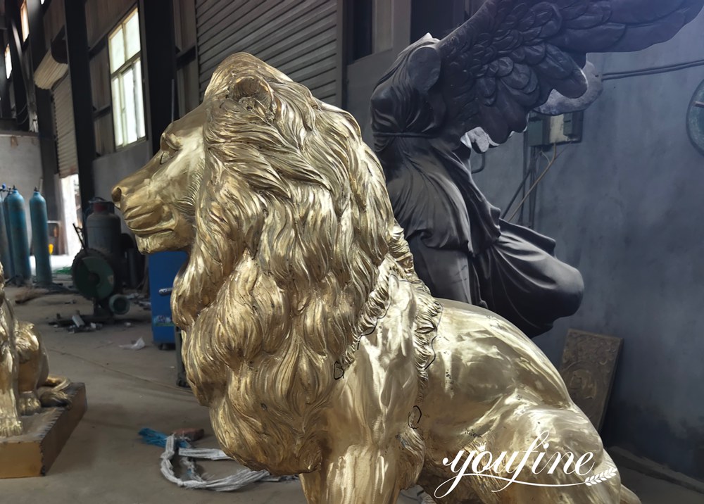 Scultura di leone in bronzo dorato lucido, vista laterale.