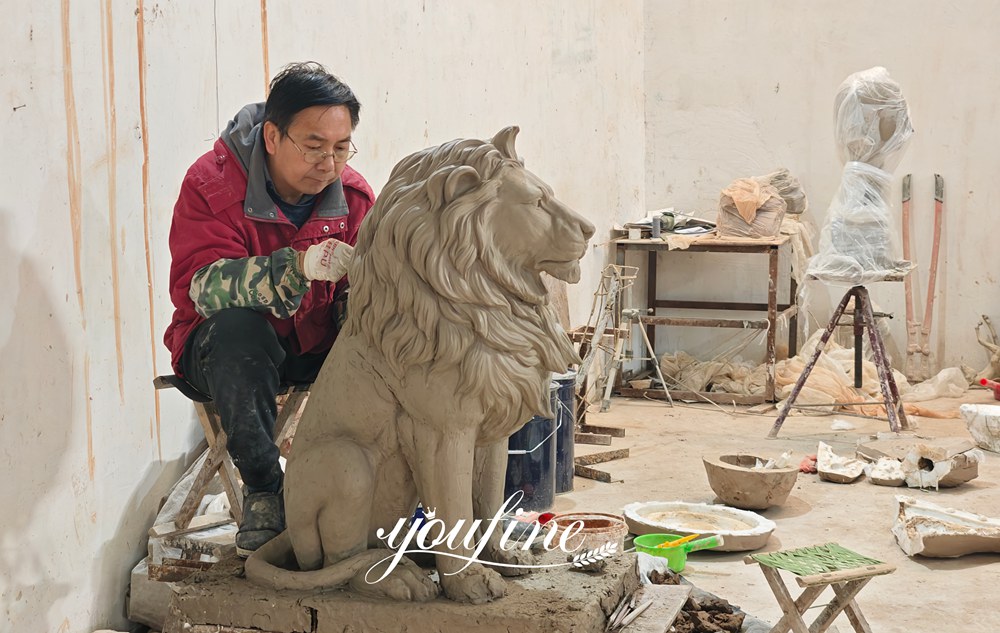 Sculptor creating clay model prototype for custom marble lion statue in art studio