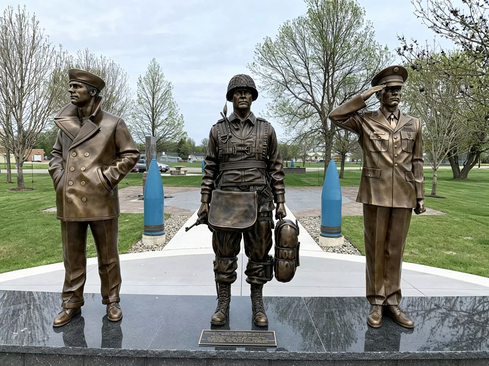bronze saluting soldier statue with flag