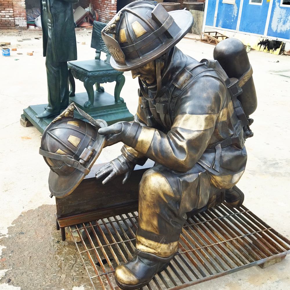 Bronzene Gedenkstatue eines knienden Feuerwehrmanns mit Helm