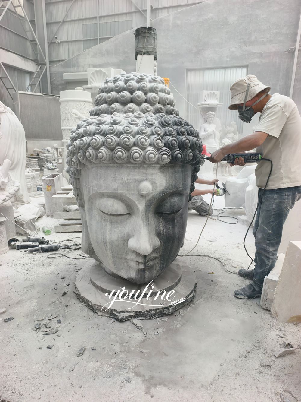 Proceso de tallado de una gran cabeza de Buda en mármol